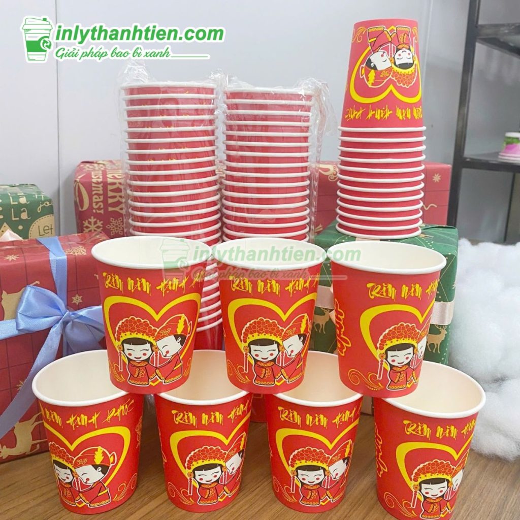 Khách cầm ly giấy 16oz in thiết kế hiện đại trước quầy pha chế